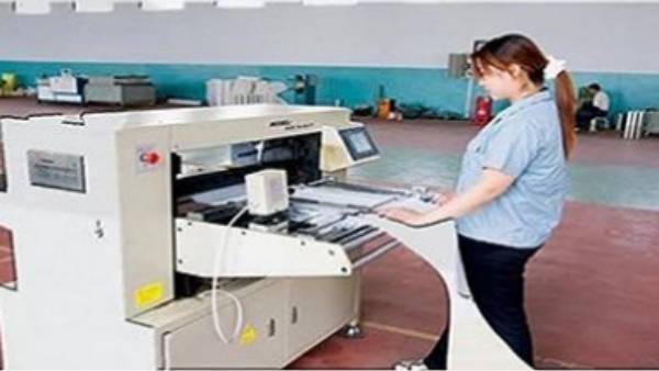 Several skilled workers are assembling hydraulic filter elements in the workshop.